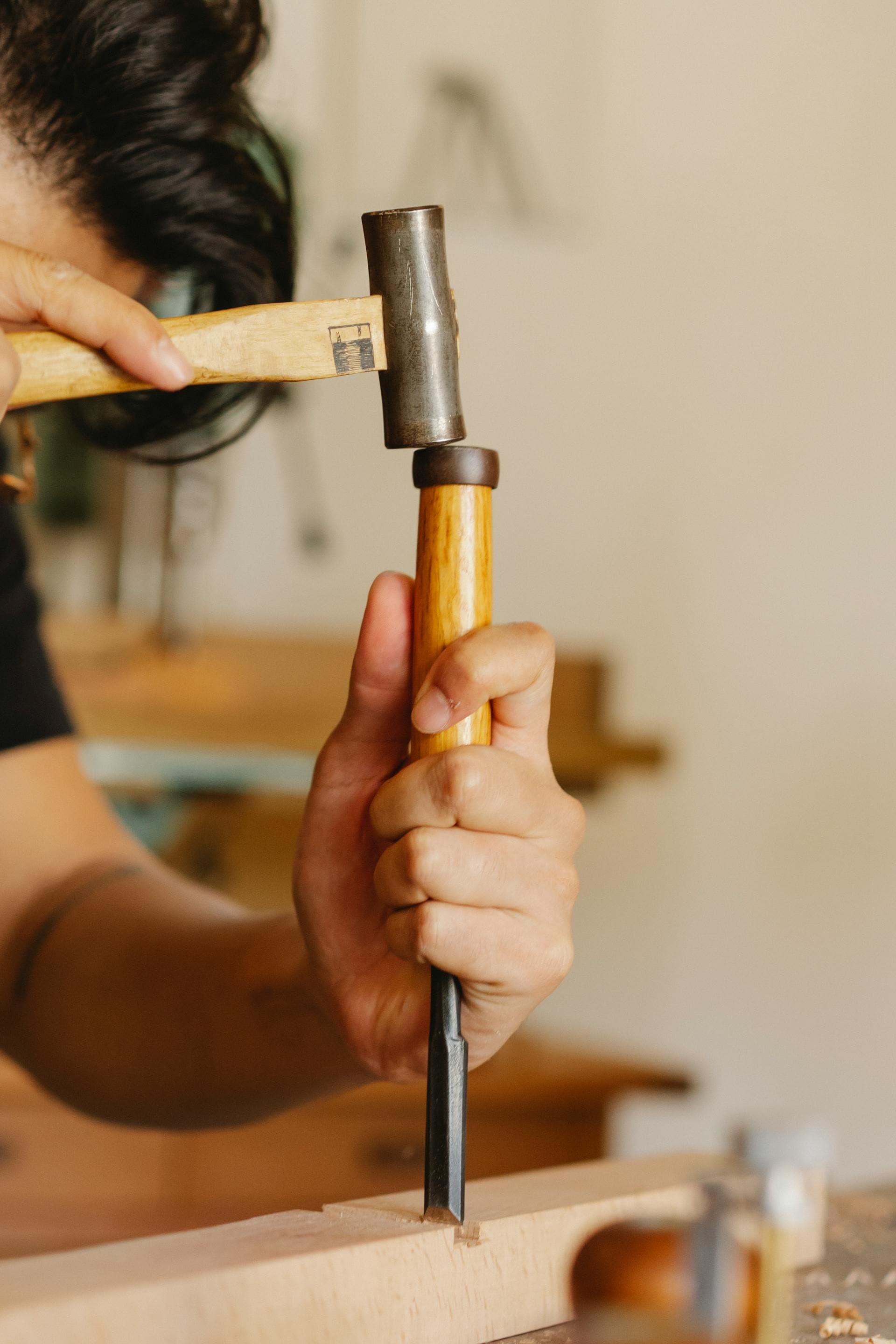 Handyman doing finish carpentry with a mallet and chisel