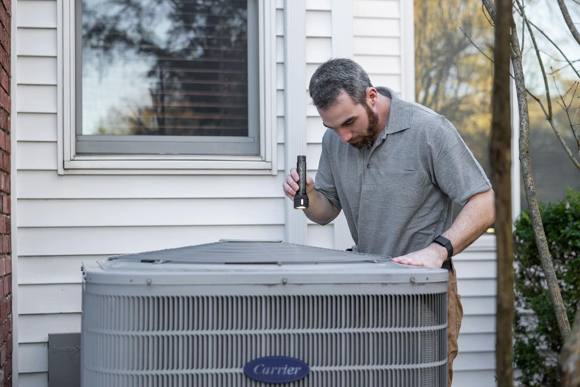 HVAC technician servicing a condenser unit